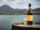 Der Caol Ila 18 Jahre vor der dramatischen Kulisse der Isle of Jura, welche direkt gegenüber der Destillerie liegt (Foto: Diageo)